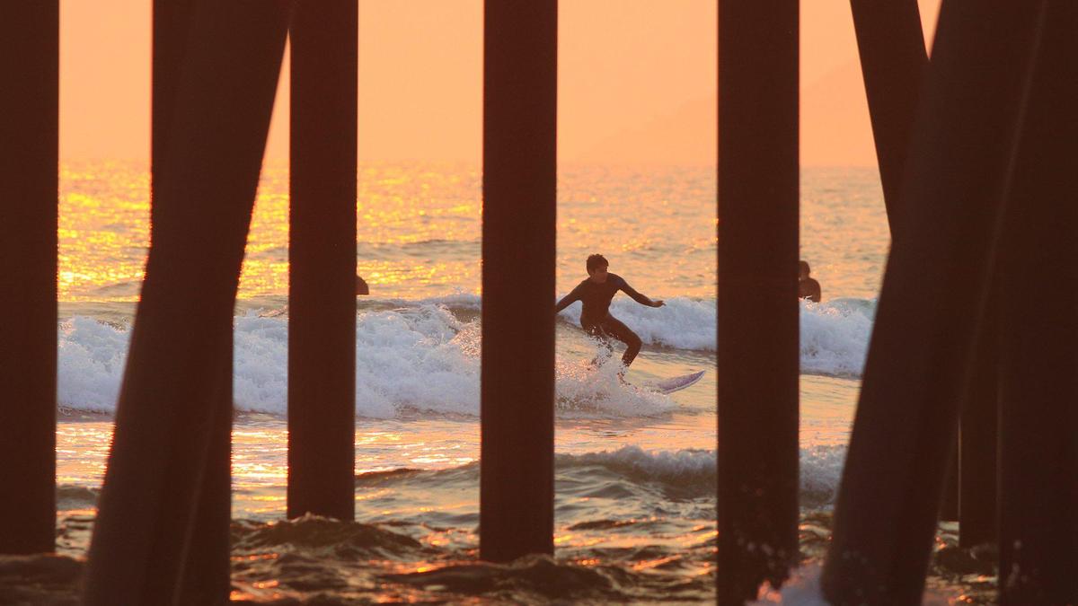 Air quality on the Central Coast is poor due to smoke from several fires burning in Monterey County. A surfer surfs near the pier in Pismo Beach on Tuesday, Aug. 18, 2020.