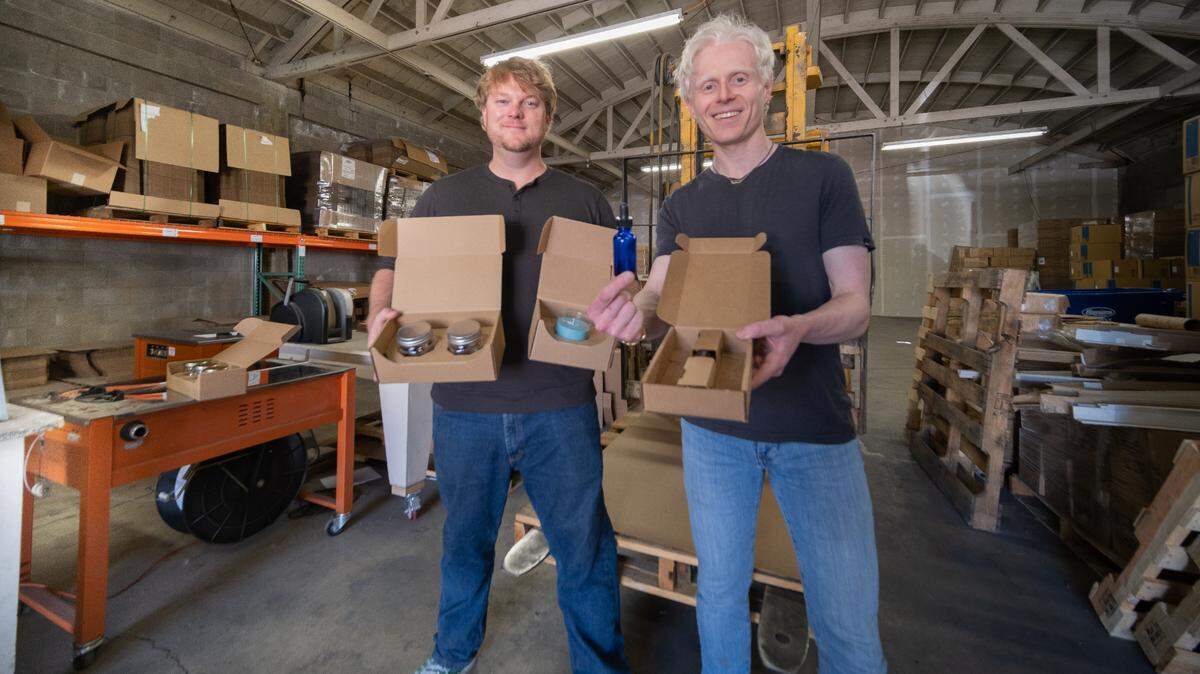 Flush Packaging CEO Heeva Asefvaziri, right, and chief financial officer Randy Baudendistel, left, pose for a picture with their custom, minimal-waste packaging in the company’s Paso Robles warehouse.