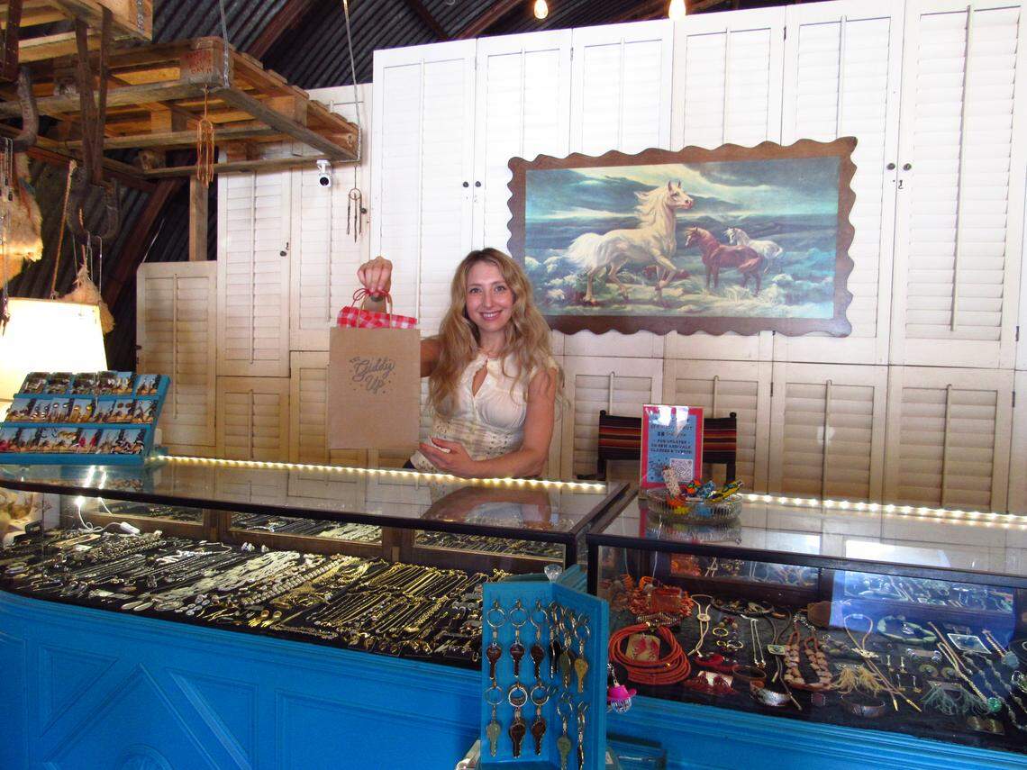 Owner of The Giddy Up Holli Rae displays a gift-wrapped bag behind the vintage shop’s counter in Santa Margarita.