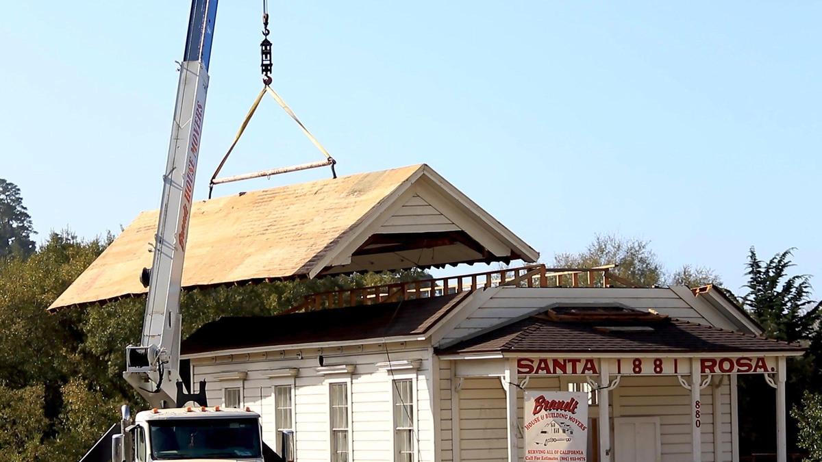 Cambria Historical Society’s Old Santa Rosa Schoolhouse was moved to a meadow on Main Street at Santa Rosa Creek Rd. A large crane was used by Brandt House and Building Movers to gingerly place the roof back on. The crane slowly inches the rooftop over the old schoolhouse.