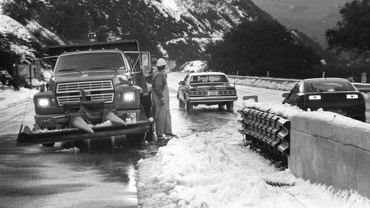 Terry Hetrick, a Caltrans equipment operator, waits for a grader to come across the road this morning as CHP escorts traffic over snow-topped Cuesta Grade March 19, 1991. David Middlecamp