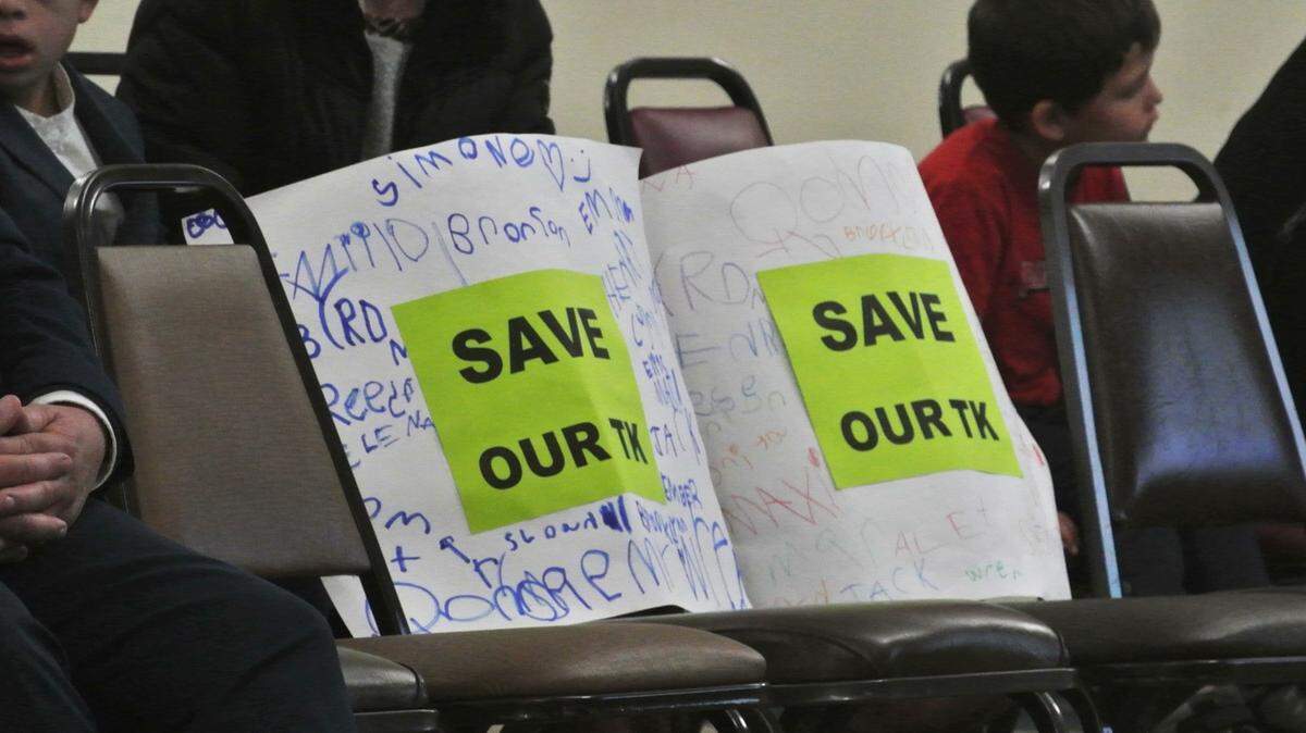 Signs reading “Save our TK” were placed in front of San Luis Coastal trustees as the board heard about impending budget cuts on Tuesday, Jan. 14, 2025.