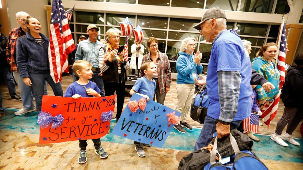 Travin 6, left and Channing Scribner, 7, of Paso Robles greet veteran John Lacey of Paso Robles with “thank you” signs. The Central Coast Honor Flight veterans arrived at the San Luis Obispo airport on Wednesday night, Oct. 26, 2022, to large, cheering crowd.