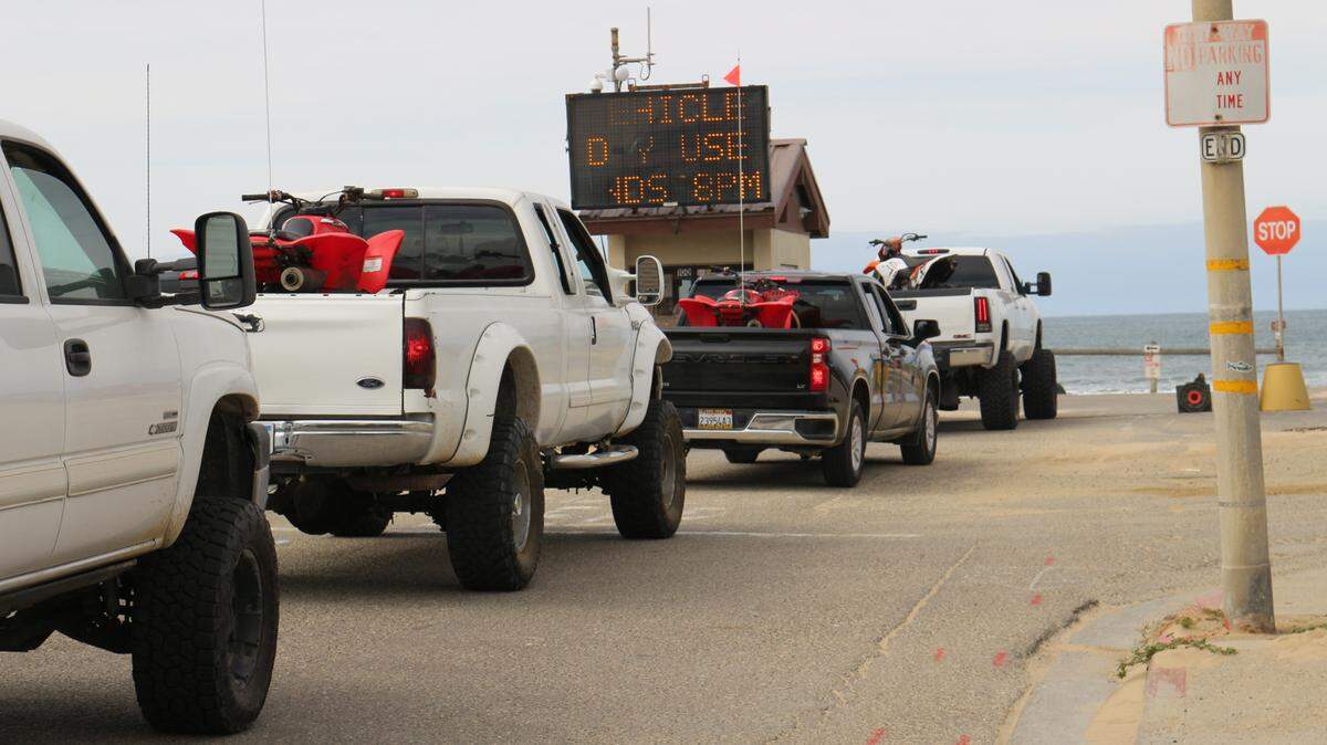 Trucks carrying ATVs line up at the Pier Avenue entrance to Oceano Dunes SVRA.