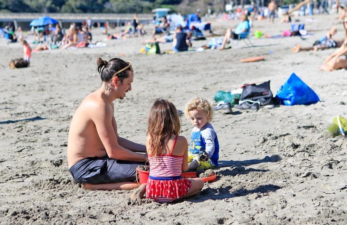 Dave Fimbres plays in the sand with his children, Avila, 5, and son Rome, 3, right, all of San Luis Obispo, during a beach outing in February.