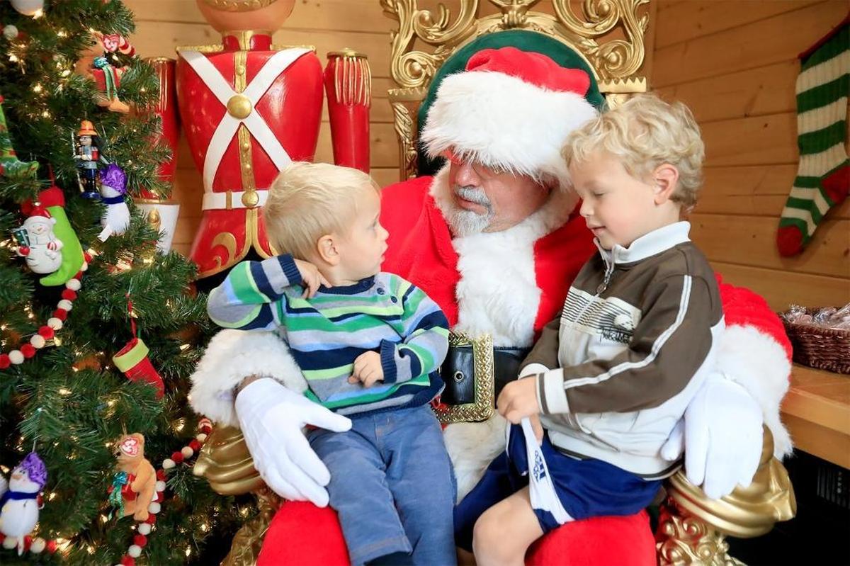 In this file photo, kids visit Santa Claus at Mission Plaza in downtown San Luis Obispo. Santa, also known as Craig Bradley, asks what Aryton Janeway, right, and his brother Levin of Los Osos would like for Christmas during last year’s holiday season.