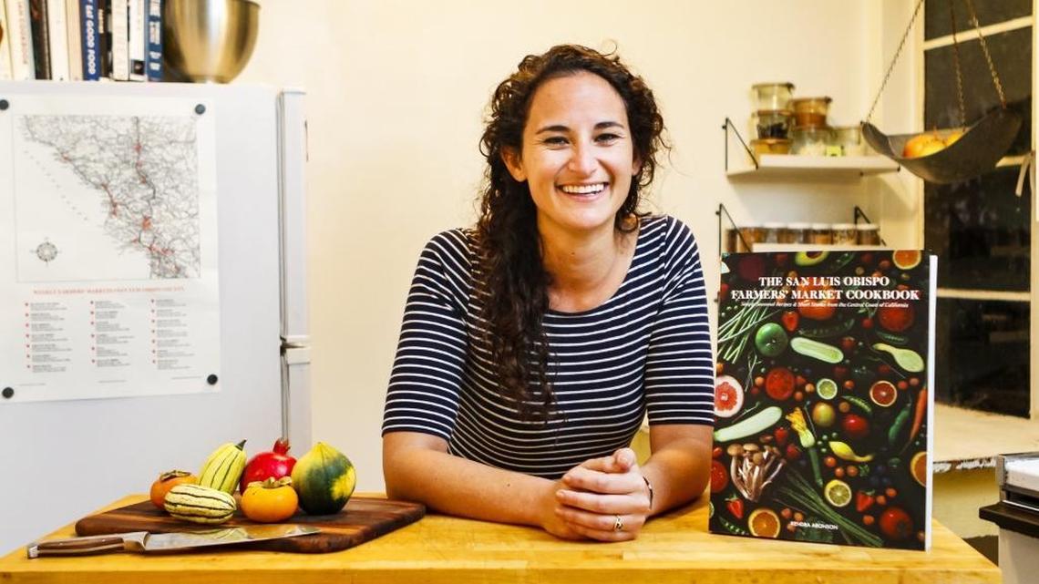 Kendra Aronson poses with her newly published book, “The San Luis Obispo Farmers’ Market Cookbook.”
