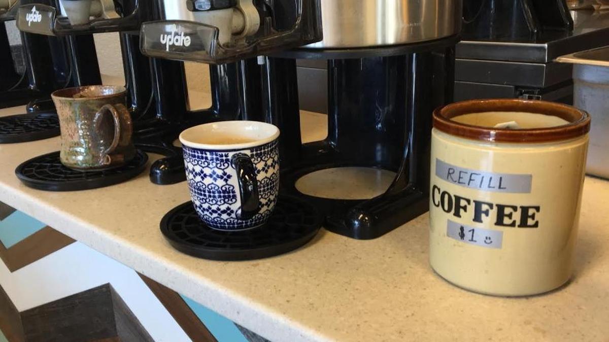 Coastal Peaks Coffee charges $1 for customers who bring their own mugs, which they can fill up at a separate table.