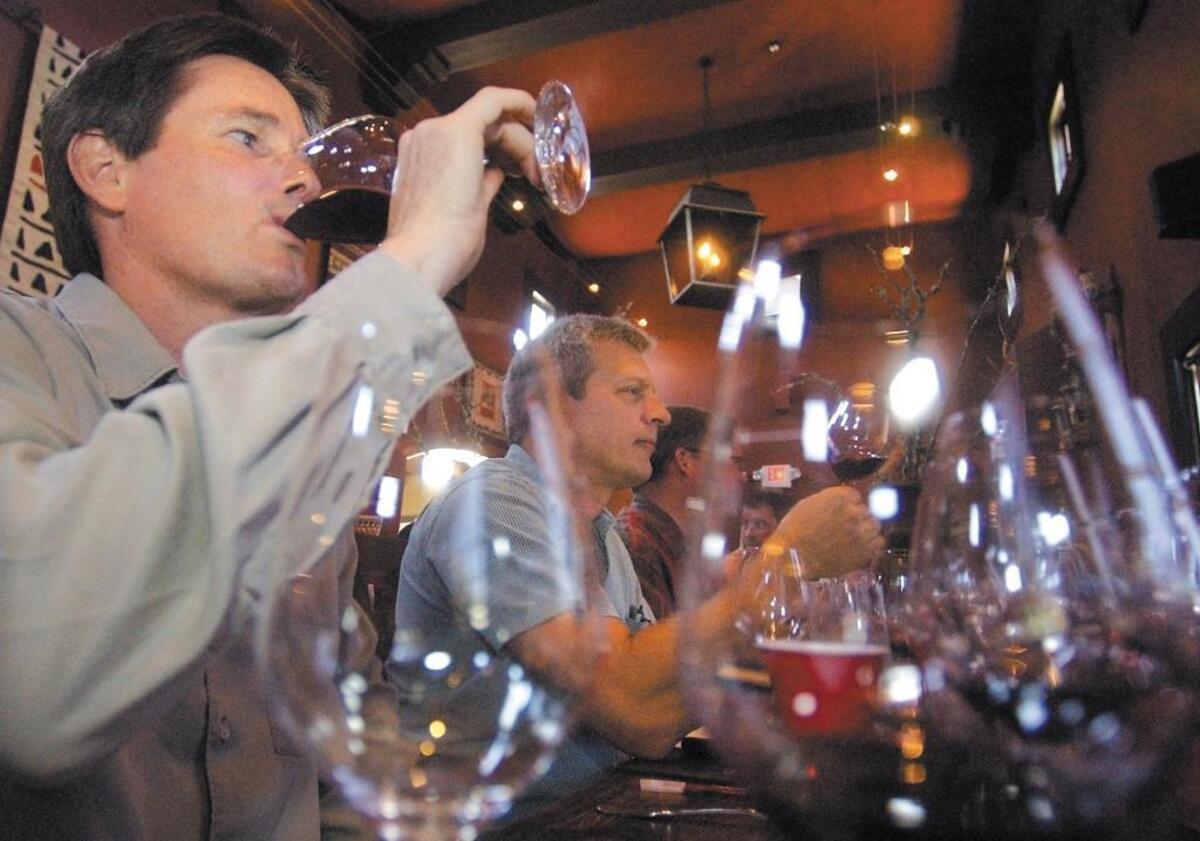 Winemakers Gary Gibson of Shadow Canyon, left, and Dan Kleck of Silverstone taste wine at a Hospice du Rhone luncheon held at Villa Creek Restaurant in Paso Robles in 2004. The 2020 Hospice du Rhone event has been rescheduled to 2021.
