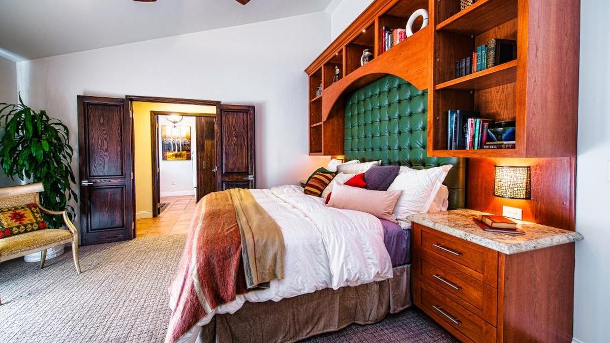 A 9-foot-tall cherry wood unit frames the headboard and incorporates two night lights, sconces and bookshelves.