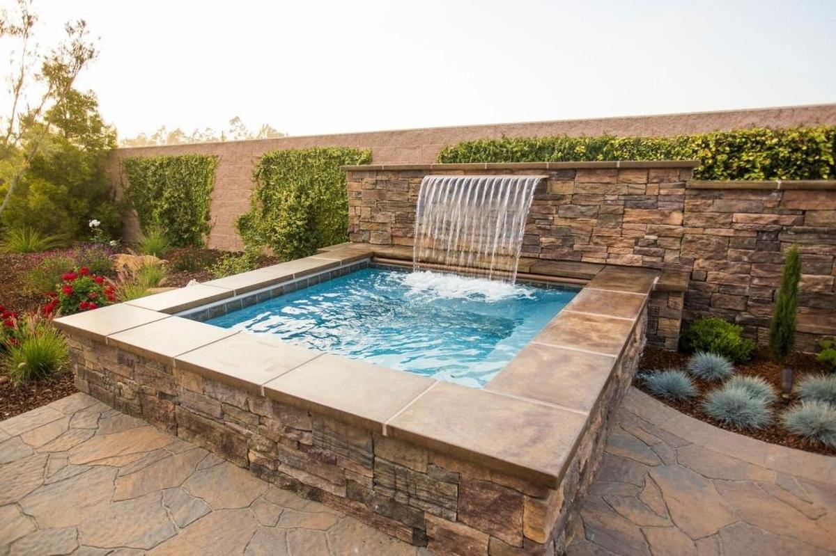 A waterfall ledge turns Susan and Michael McMillan’s backyard Nipomo spa into a dramatic water feature and adds another organic element to the backyard.