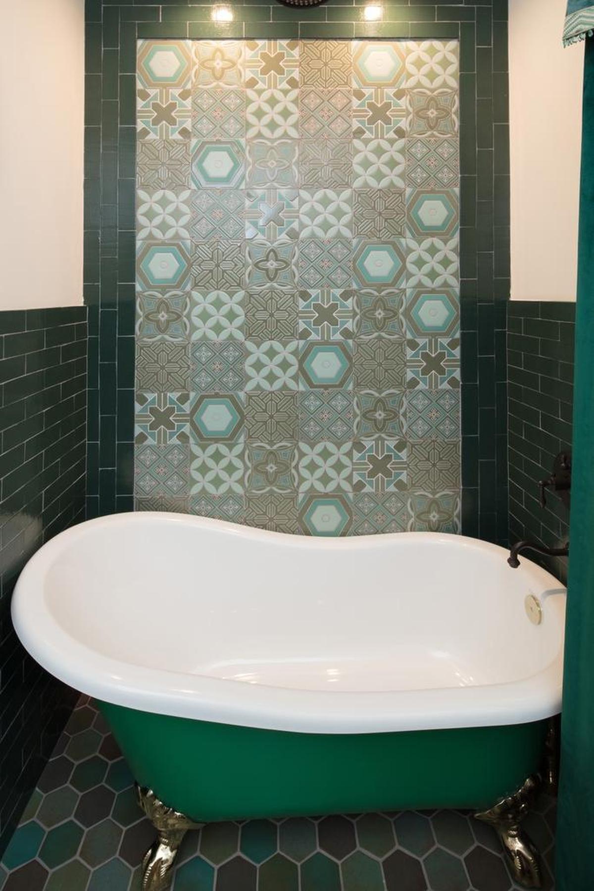 The hall bathroom features shades of green and blue because they remind Zoe Sunderland of water. The clawfoot tub is deep green.
