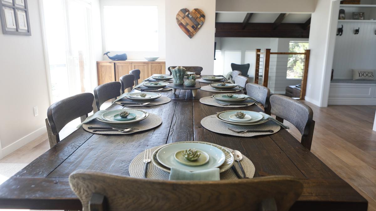 A weathered wood farmhouse table and schoolhouse-style chairs sit in the dining room of the Cambria home owned by John and Diane Somers.