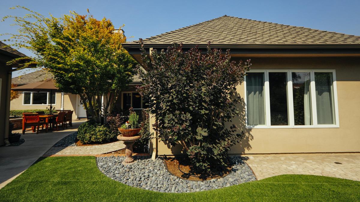 Dale and Laura Texter’s San Luis Obispo backyard features an outdoor eating area, artificial turf and multiple planting beds outlined by concrete, stones and bricks.