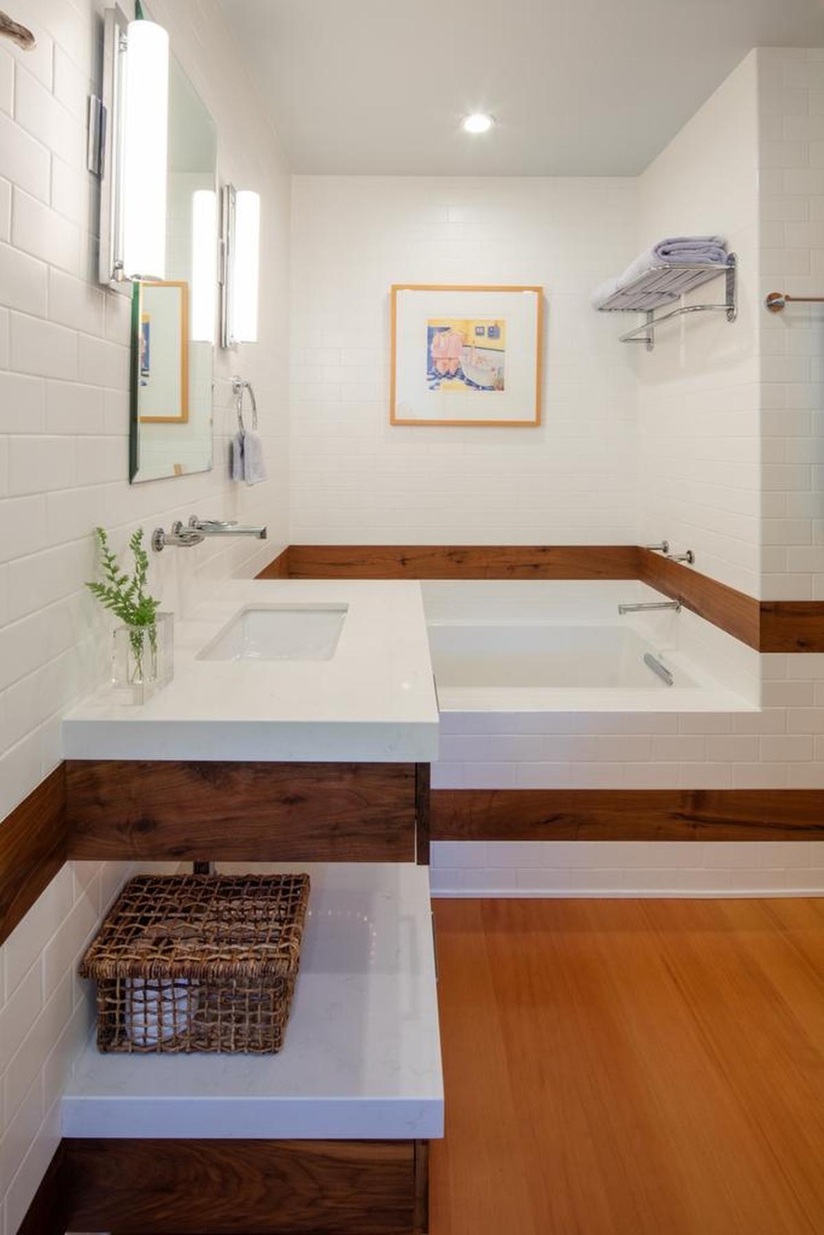 A combination of wood and tile with the look of wood breaks up the expanse of white tile in the guest bathroom.