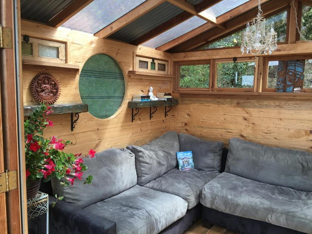 Susan Unkel’s she-shed features a round “moon window” created by local glass artist Ted Emrick and two antique colored glass windows from India.