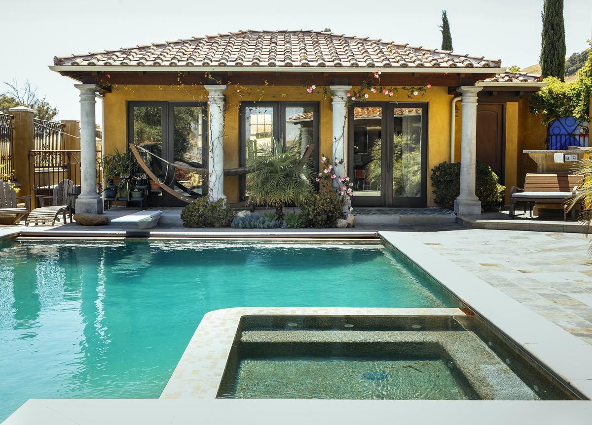 A detached pool house sits beside a 66-foot lap pool with diving board and integrated hot tub at Rushdi and Nisha Abdul Cader's San Luis Obispo home.