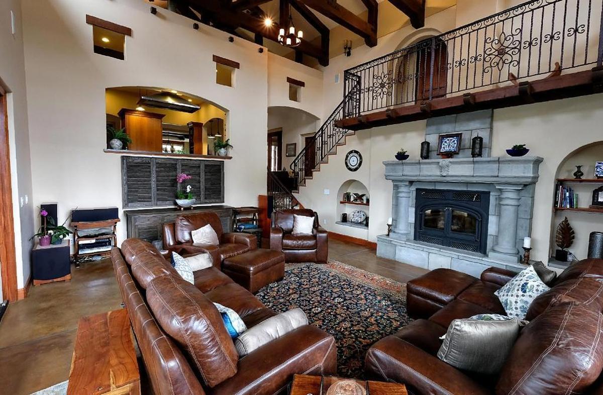 Wrought iron railings and heavy ceiling beams add Old World style to the great room in Rushdi and Nisha Abdul Cader’s San Luis Obispo home.