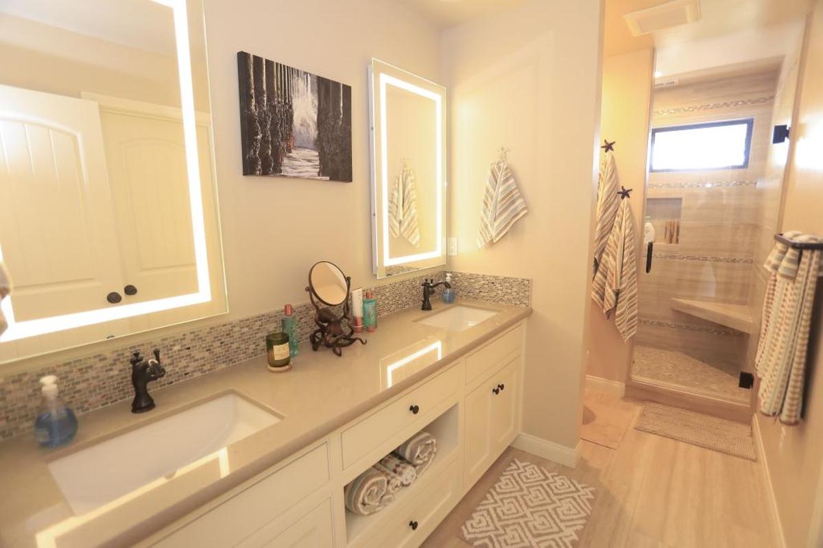 Beach-inspired pebble flooring lines the shower of a bathroom of Doug in Shelly Schultz’s Cambria home