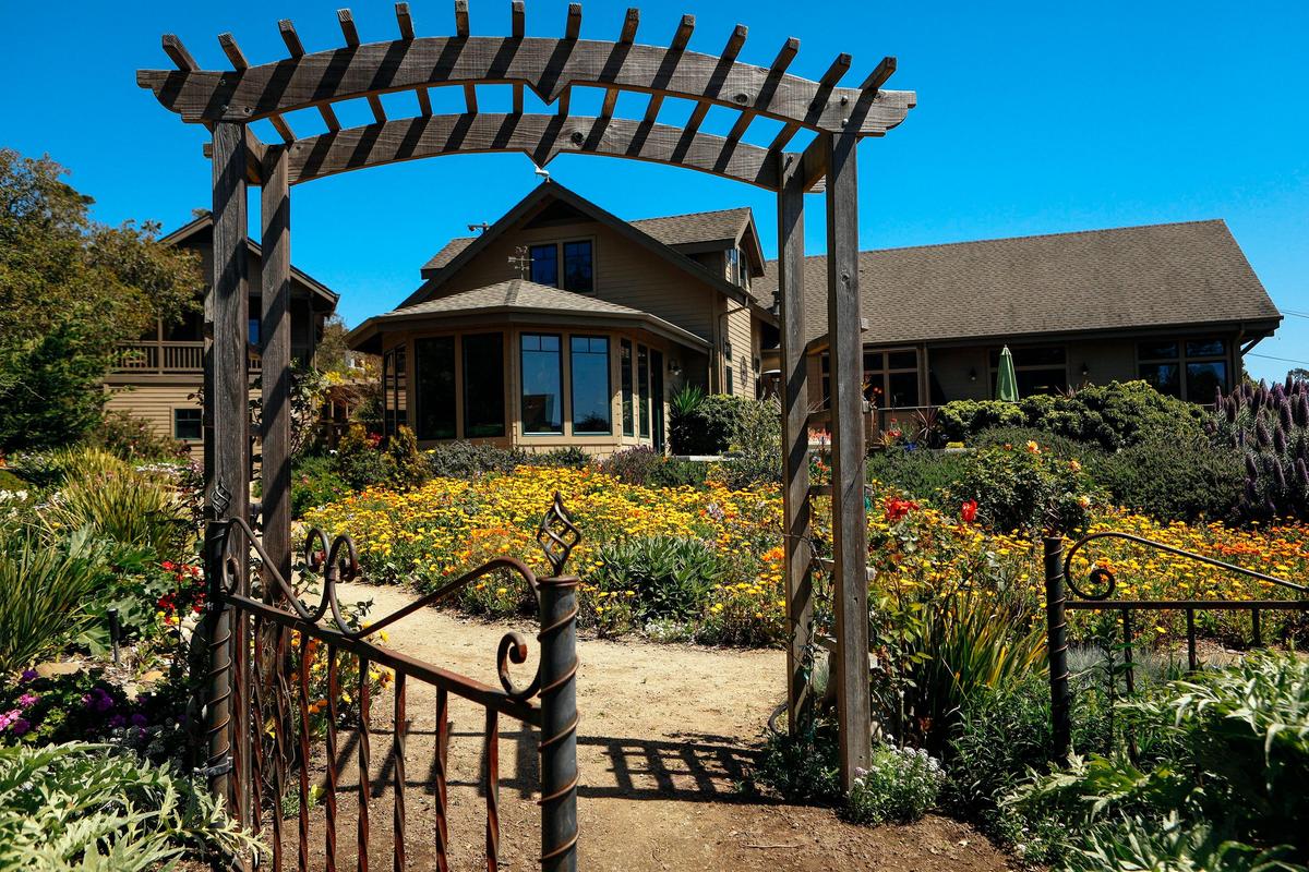 A large gate leads to the lush backyard of Lee Oliphant and Don Sather's Cambria home.