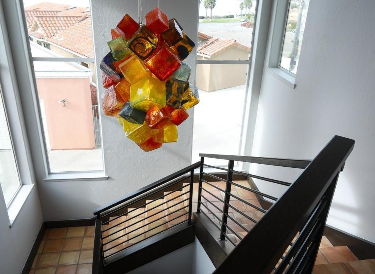 A glass sculpture created by Seattle artist Joe McDonnell doubles as a statement-making chandelier in the Sardellas’ Shell Beach home.