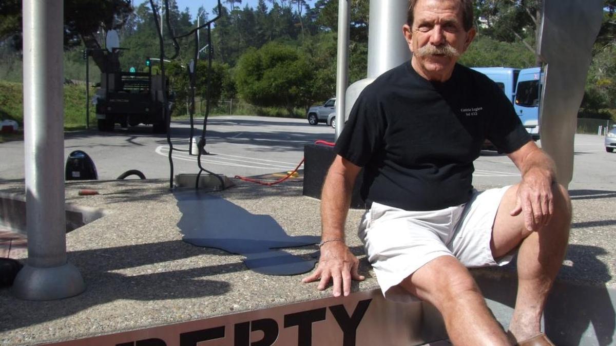 Cambria resident Jay Burbank sits next to his “Missing In Action” sculpture.
