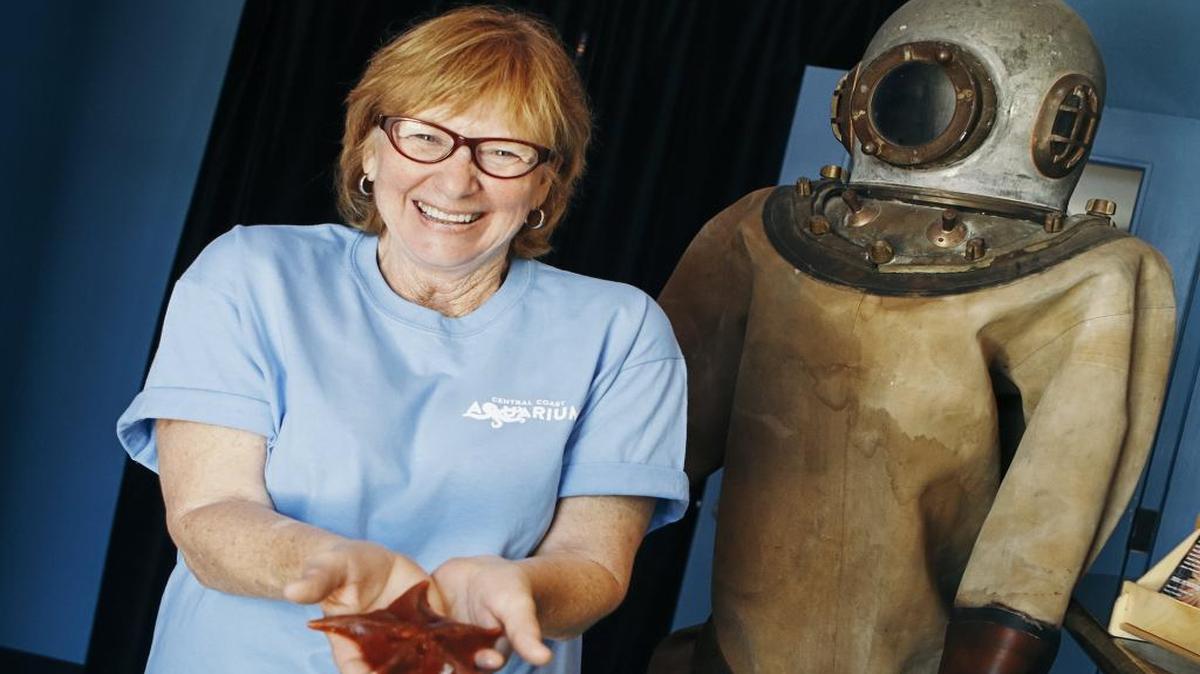 Avila Beach resident Debbie Collins holds a bat star at the Central Coast Aquarium, where she is a member of the board of directors.