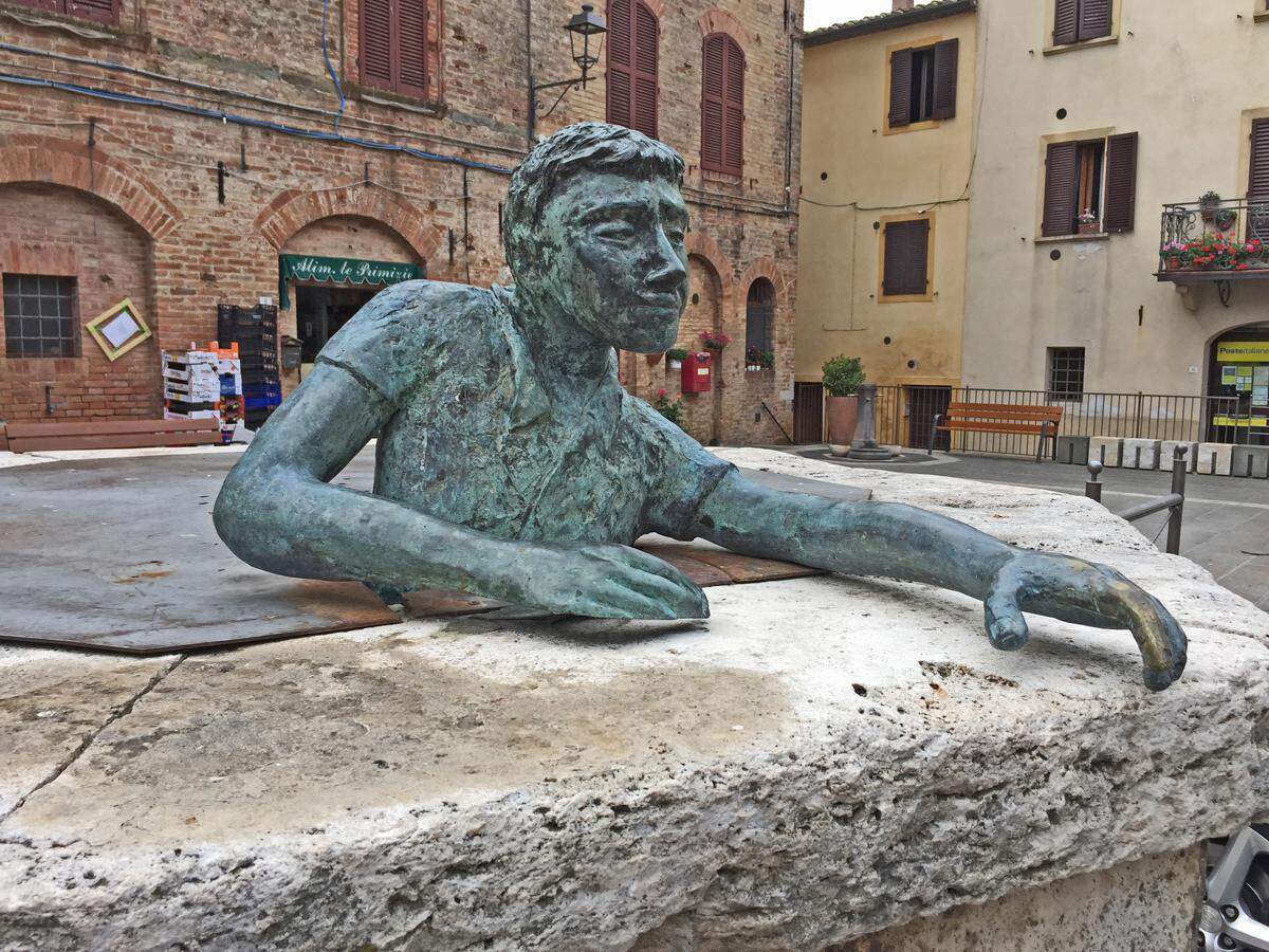 A whimsical sculpture in Casole d’Elsa, Italy, depicts a young man climbing out of a capped well.
