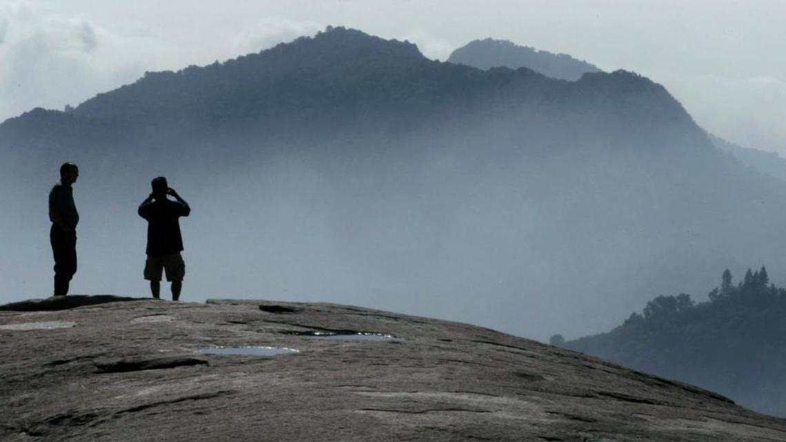 Visitors look south from smog-shrouded Beetle Rock in Sequoia National Park.
