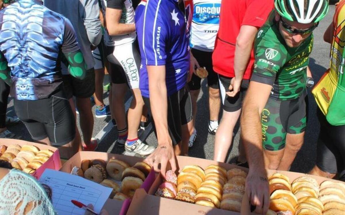 Bicyclists chow down on doughnuts in front of SLO Donut Co. during the Tour de Donut in 2014.
