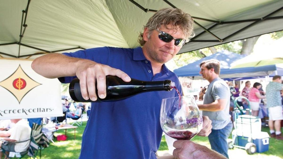 Doug Kruse,owner of Jack Creek Cellars, pours a glass of pinot at the 2013 Pinot & Paella Festival.