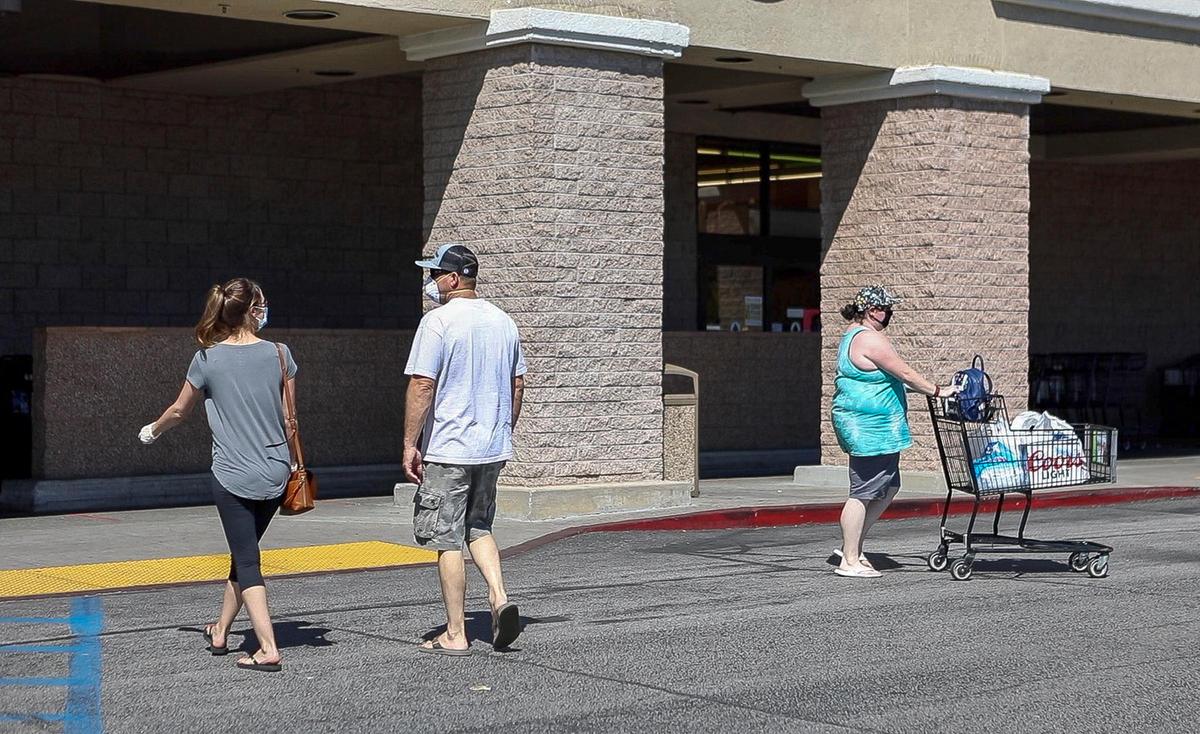 People wearing masks enter and exit the Albertons in Paso Robles. The store is requiring that all customers and employees wear face coverings.