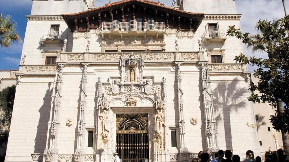 A tour group gathers in the shade in the plaza in front of Casa Grande at Hearst Castle.