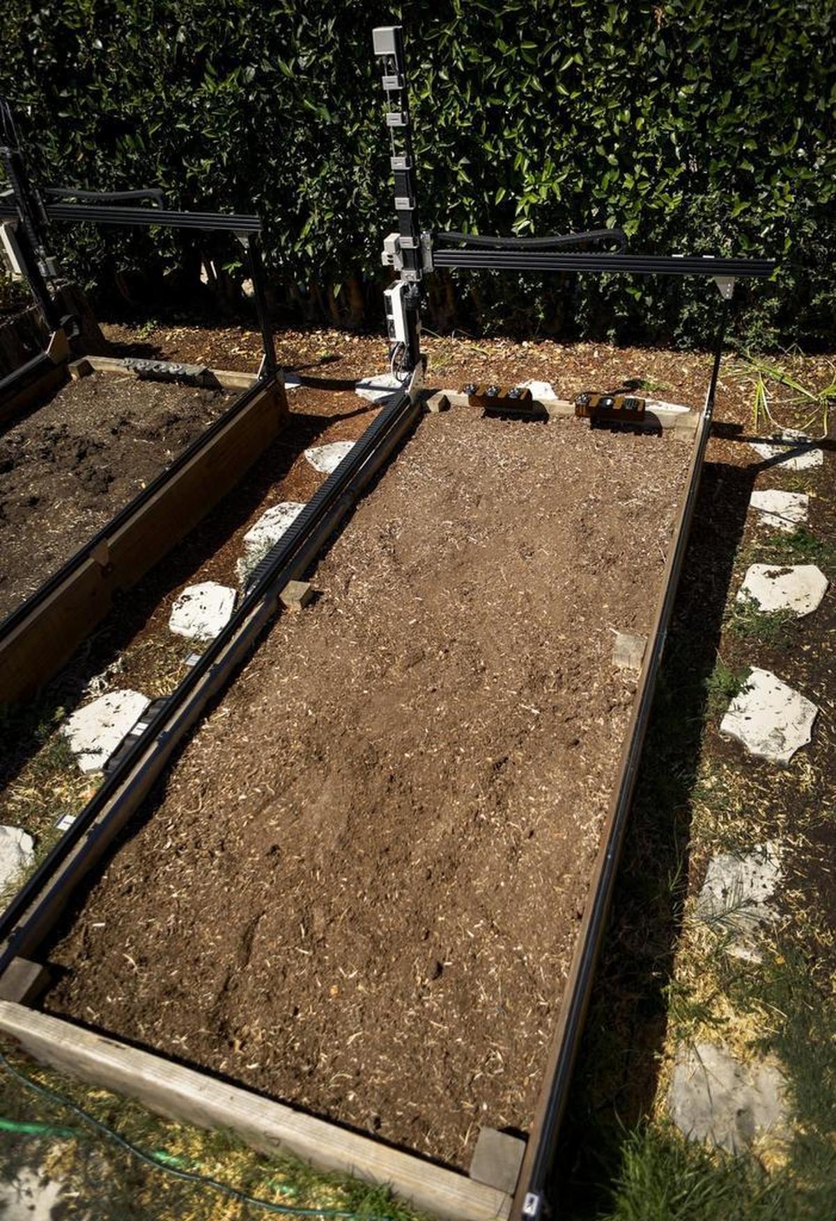 A raised bed of soil is ready for a new planting by FarmBot.