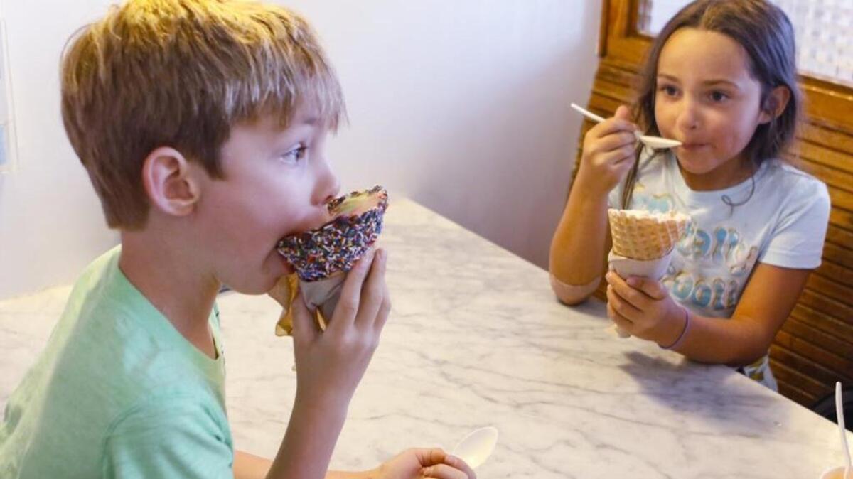 Jackson Baker, 6, tackles a cone of Straight to the Dentist ice cream, while Gwen Cooper, 8, has a combination of Caramel X-plosion and Birthday Cake at Doc Burnstein’s Ice Cream Lab in Arroyo Grande.