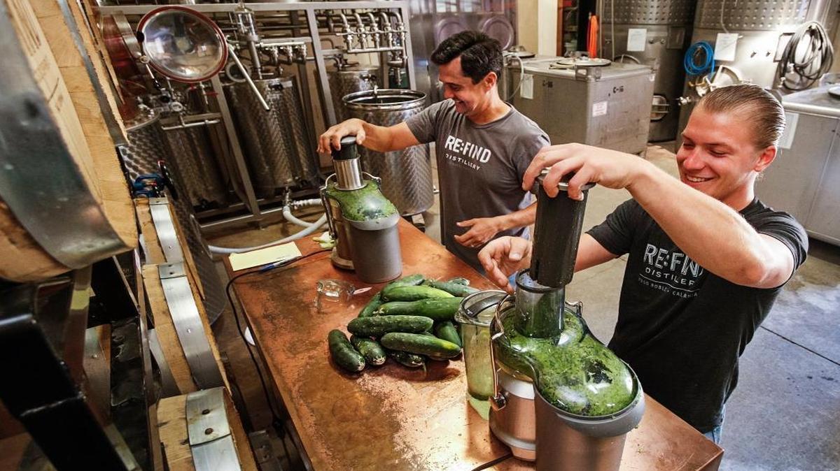 Alex Villicana, left, and Adam Scheiderer juice cucumbers for a cucumber infused vodka at Re:Find Distillery in Paso Robles.