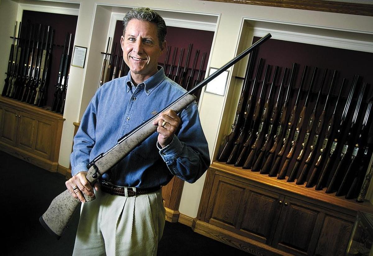 Ed Weatherby, shown in a 2005 photo, turned over the job of CEO to his son, Adam Weatherby, last year. Here, he holds one of the company’s rifles, a Vanguard Sub M.O.A., at his Atascadero showroom.