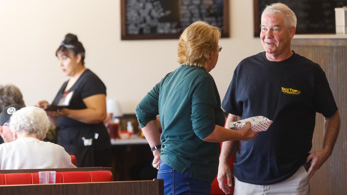 General manager Patrik Lynch talks to Paula Frojae, one of the first customers at the new Taco Temple restaurant in San Luis Obispo.
