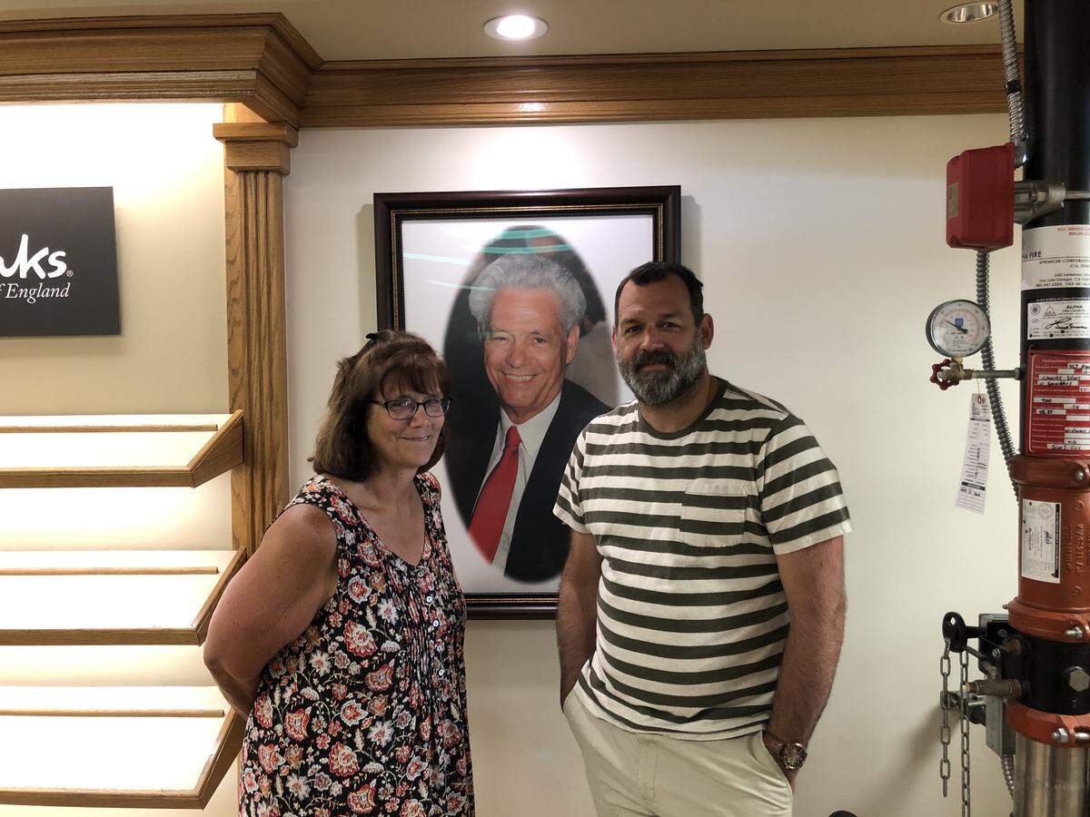 Charles Shoes co-owner Cyndi Ashley with her son Jason Ashley, a longtime store employee. Ken Porche, Cyndi’s father, who first owned the store in 1966, is pictured in the portrait.