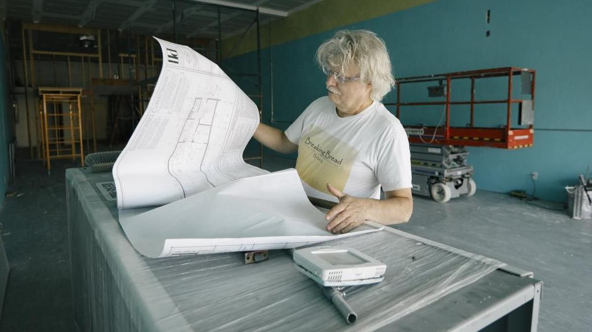 Breaking Bread Bakery co-owner Mark Evans looks over design plans for the bakery's new location in Tenwise Park on South Higuera in San Luis Obispo.