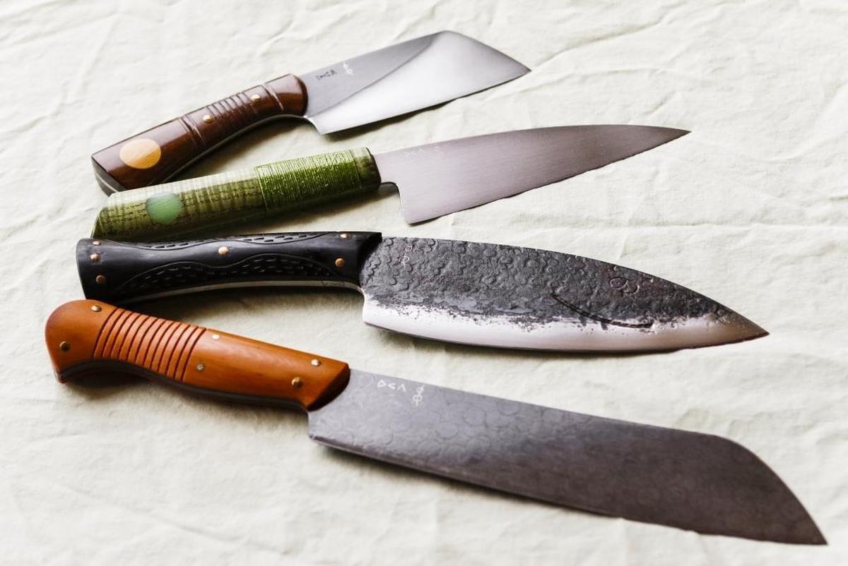 A finished camp cleaver, top, French knife, Happy Fish camp knife, and a backpackers parang made by Don Carlos Andrade of California Custom Knives in Los Osos.