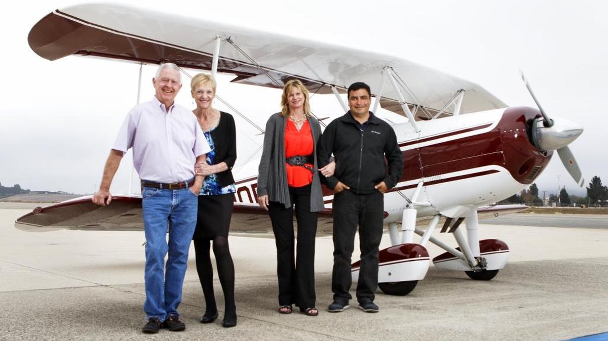 Adam Verdin, right, his wife Mary and Adam’s sister Eva (not pictured) are buying the Spirit of San Luis restaurant at the San Luis Obispo County Regional Airport from Doug and Julie Wagnon. They’re pictured in front of Adam Verdin’s vintage biplane.