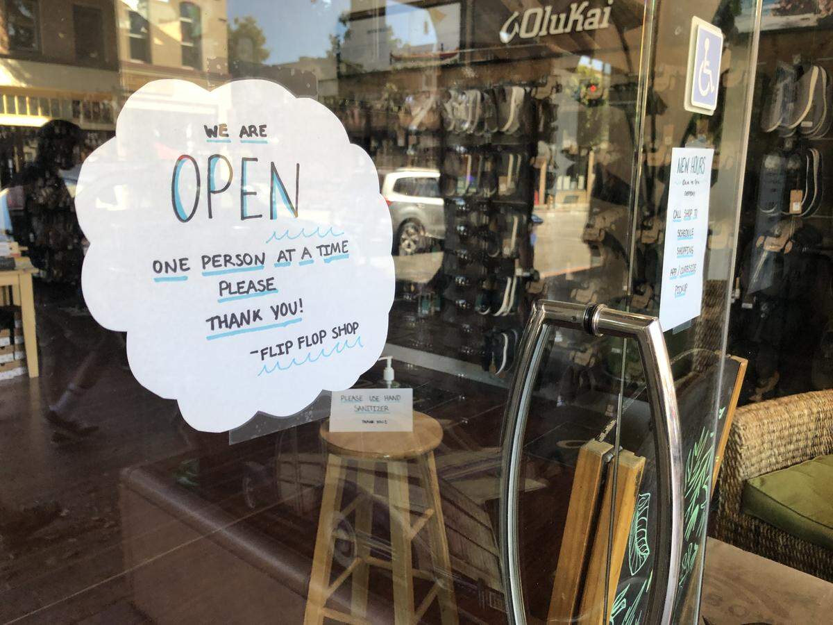 A sign posted by the Flip Flop Shop in SLO asks customers to enter the store one at a time.