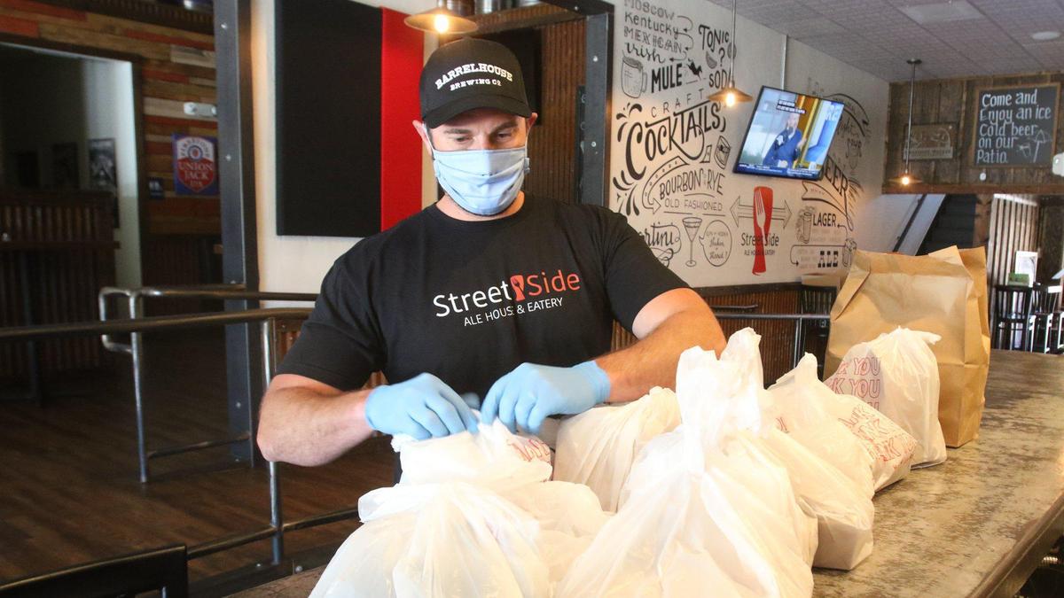 Eric Peterson co-owns Street Side Ale in Atascadero, checks a take out order. Peterson has had to adjust the business model to serve takeout and pickup, versus dine in. Business is slowly starting to pick up and his workers have clear instructions on keeping things safe and virus free.
