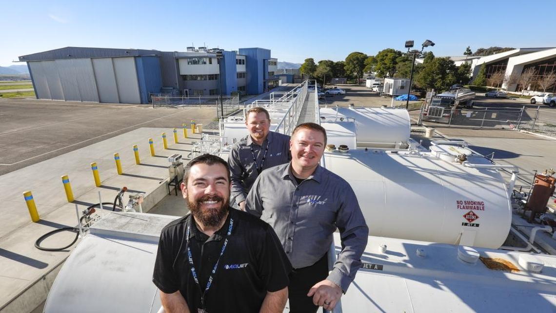 Top executives at ACI Jet of San Luis Obispo, front to back, are Andrew Robillard, vice president of flight-based operations and facilities; Kellee Valentine, vice president of flight operations; and Dave Jensen, vice president of aircraft maintenance. Behind them is the former American Eagle facility that ACI has remodeled.