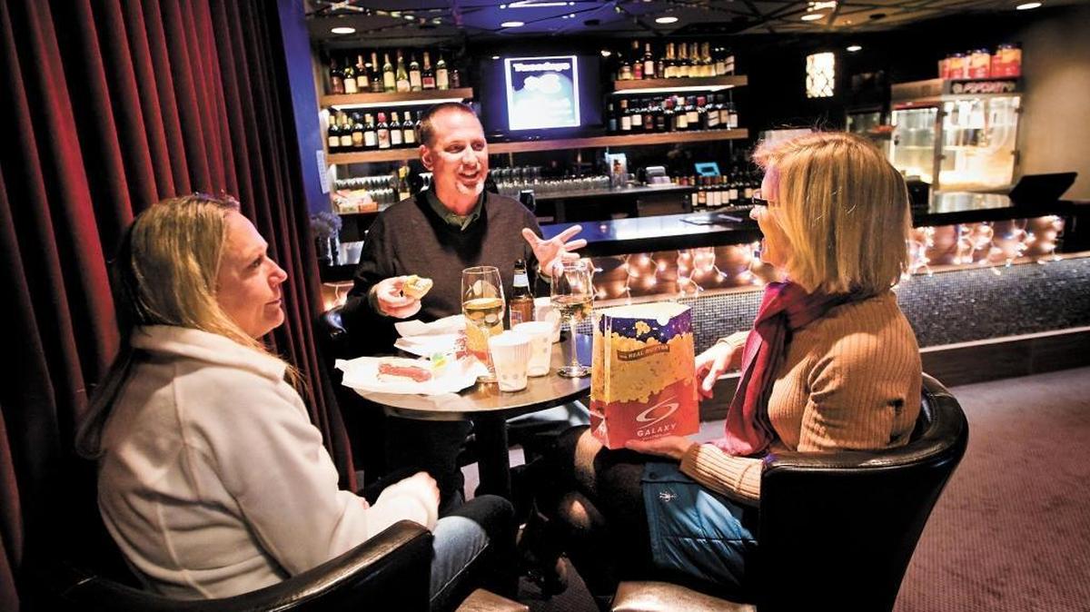 Melanie Lighfoot, left, her husband Ashley of Atascadero and their friend Anita Pedersen of Colorado enjoy some wine, beer and snacks in the VIP area at the Galaxy Theatres in Atascadero before the start of their movie. Galaxy Theatres was the first movie theater in the county to start selling wine and beer, an option now being pursued by the Regal Arroyo Grande Stadium 10 movie theater.