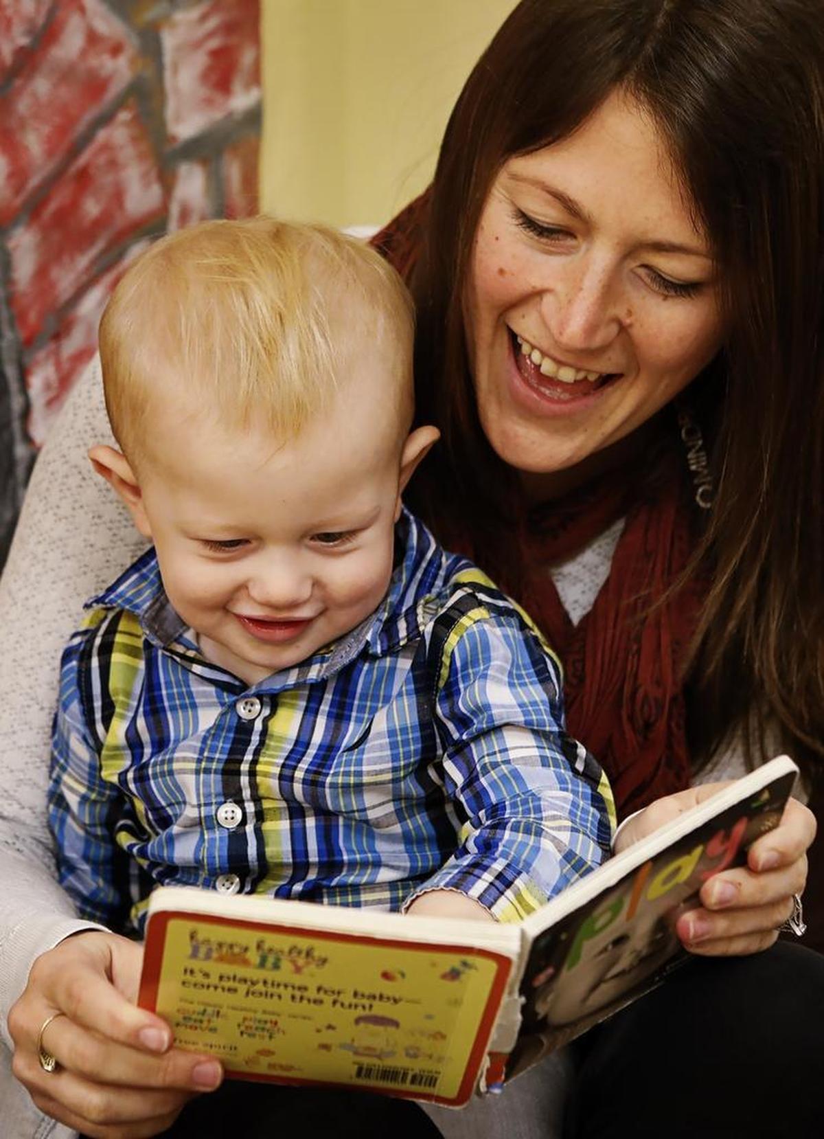 MindBody employee Noelle Feist takes a break from her workday to visit and read a book to her son, Oden, at the Little Ensos center at MindBody in San Luis Obispo.