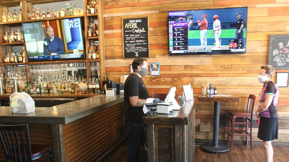 David Greenaway rings up a take out order for Cindy Ursprung at Street Side Ale House in Atascadero. Coronavirus has lead to the business expanding takeout service.