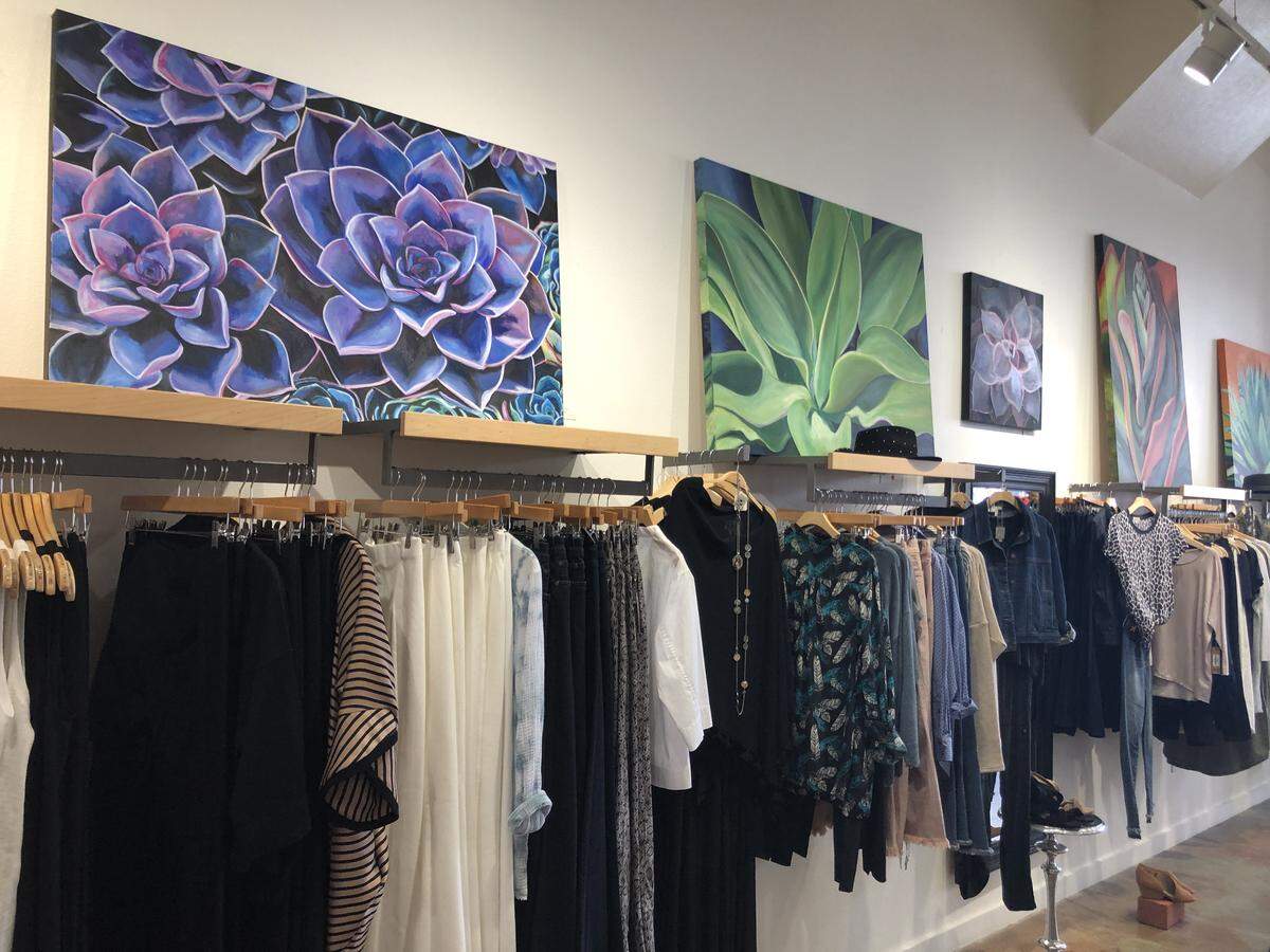 Clothes at 2 Blondes Boutique in SLO are displayed. on a wall. The store is up for sale.