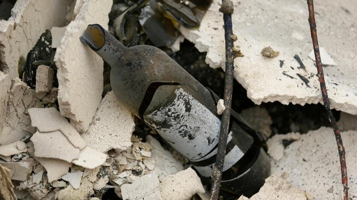 A burned bottle of wine rests in the rubble at the Signorello Estate Winery in Napa. Worried California vintners surveyed the damage to their vineyards and wineries Tuesday after wildfires swept through several counties whose famous names have become synonymous with fine food and drink.